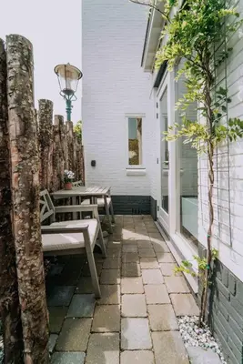 a patio with two benches on the side of a house at Tiny Beach House Zandvoort in Zandvoort