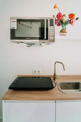 a microwave oven sitting on top of a kitchen counter at Tiny Beach House Zandvoort in Zandvoort