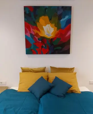 a bedroom with a bed with a painting on the wall at Luxury Suites Oosterwold in Almere