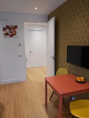 a room with a table and a door with a television at Luxury Suites Oosterwold in Almere