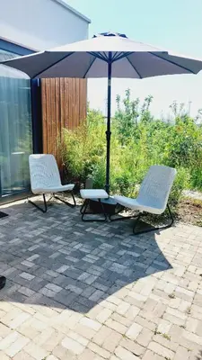 two chairs and an umbrella on a patio at Luxury Suites Oosterwold in Almere