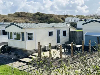 a small white house sitting on top of a yard at Duindoorn 45 in IJmuiden