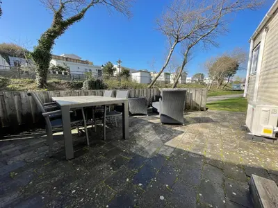a patio with a table and chairs and a fence at Duindoorn 45 in IJmuiden