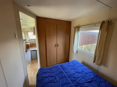 a bedroom with a blue bed and a window at Duindoorn 46 in IJmuiden