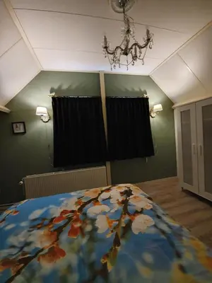 a bedroom with a bed and a chandelier at Bed & breakfast FF rust in Kockengen