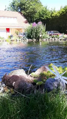 a body of water with two rocks in the grass at Bed & breakfast FF rust in Kockengen