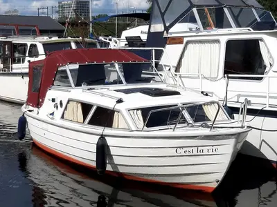 a white boat is docked in the water at Motor Yacht Almaz in Amsterdam