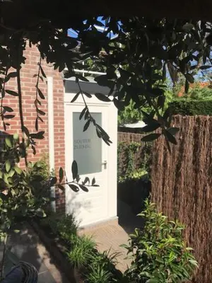 a white door in a brick building with birds on it at Souterrain Zuid-Duinen -Free Parking in Zandvoort