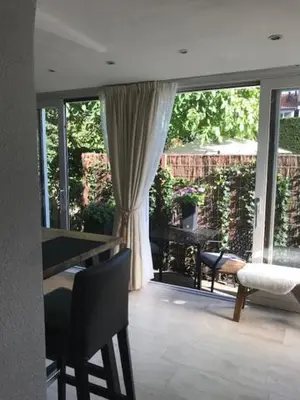 a living room with a large window and a table and chairs at Souterrain Zuid-Duinen -Free Parking in Zandvoort