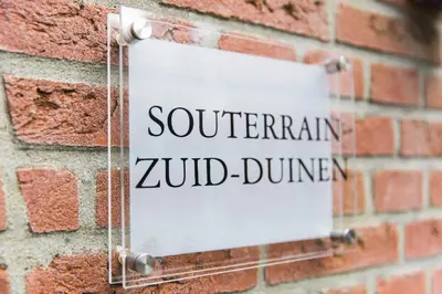 a sign on a brick wall that reads southern yard dunimer at Souterrain Zuid-Duinen -Free Parking in Zandvoort