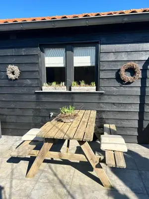 a wooden picnic table in front of a house at Chalet peter in Limmen