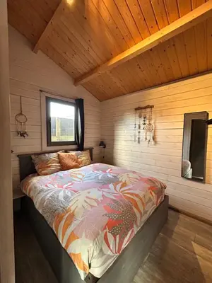 a bedroom with a bed in a wooden room at Chalet peter in Limmen