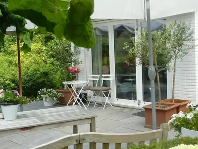 a patio with a wooden bench and some plants at Bed and Breakfast Valckenbosch in Zeist