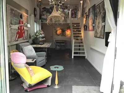 a living room with a yellow chair and a table at Bed and Breakfast Valckenbosch in Zeist