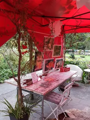 a table under a red umbrella with pictures on it at Bed and Breakfast Valckenbosch in Zeist