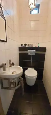 a bathroom with a white toilet and a sink at House close to beach and city in Hoorn
