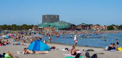 a large group of people on a beach at House close to beach and city in Hoorn