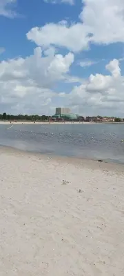 a beach with a building in the distance and the water at House close to beach and city in Hoorn