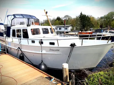 a white boat is docked at a dock at Motor Yacht Amazone in Amsterdam