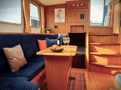 a living room with a blue couch and a table at Motor Yacht Amazone in Amsterdam