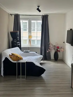 a bedroom with a large bed and a window at Beach Studio in Zandvoort