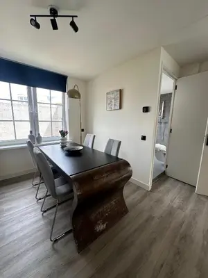 a dining room with a wooden table and chairs at Beach Studio in Zandvoort