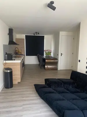 a living room with a couch and a kitchen at Beach Studio in Zandvoort