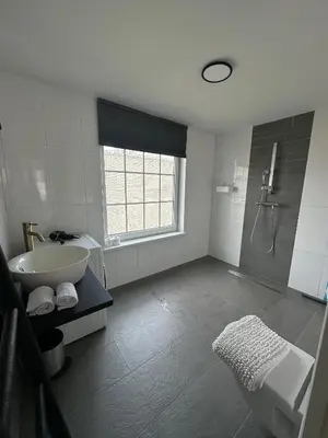 a bathroom with a tub and a sink and a shower at Beach Studio in Zandvoort