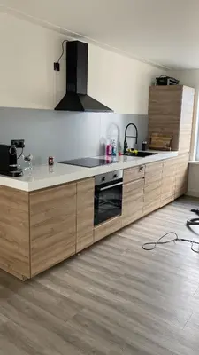 a kitchen with wooden cabinets and a stove top oven at Beach Studio in Zandvoort