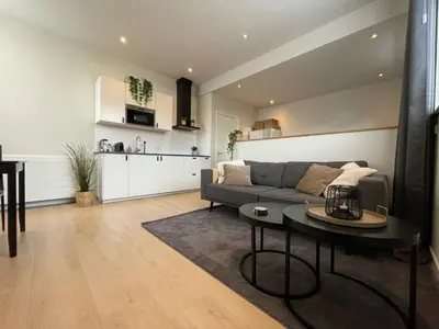 a living room with a couch and a table at Studio River, Luxe dichtbij strand en Duinen in Egmond aan Zee