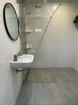 a bathroom with a sink and a shower with a mirror at Studio River, Luxe dichtbij strand en Duinen in Egmond aan Zee