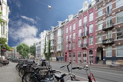 a row of bikes parked on a city street at Krisotel in Amsterdam