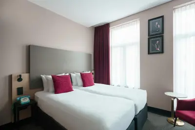 a hotel room with two beds with red pillows at Krisotel in Amsterdam