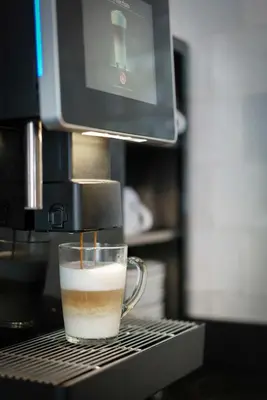 a cup of coffee is coming out of a coffeemachine at Krisotel in Amsterdam