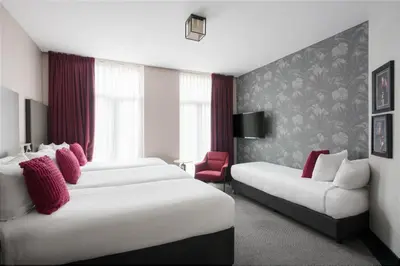 a hotel room with two beds and a couch at Krisotel in Amsterdam