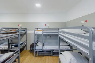 a bunk room with three bunk beds in it at Hostel Warmoes Amsterdam in Amsterdam