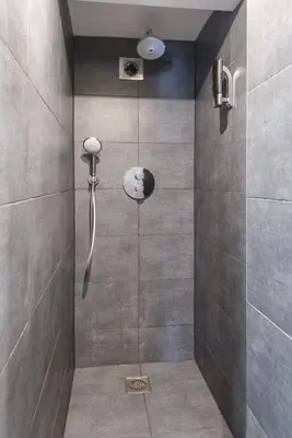 a shower with a shower head in a bathroom at Hostel Warmoes Amsterdam in Amsterdam