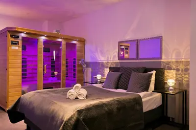 a bedroom with a large bed with purple lighting at Wellness Suite Zeist in Zeist