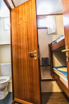 a bathroom with a door to a room with a bunk bed at Amice in Haarlem