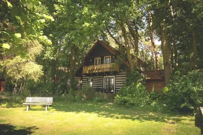 a bench in front of a small house in a park at 't Eekhoornnest in Soest