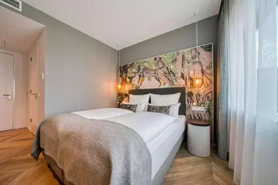 a bedroom with a large bed with a painting on the wall at Vienna House Easy by Wyndham Amsterdam Airport Schiphol in Hoofddorp