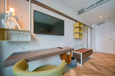 a room with a desk with a tv and a chair at Vienna House Easy by Wyndham Amsterdam Airport Schiphol in Hoofddorp