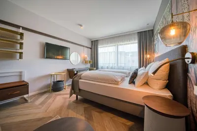 a bedroom with a large bed and a window at Vienna House Easy by Wyndham Amsterdam Airport Schiphol in Hoofddorp