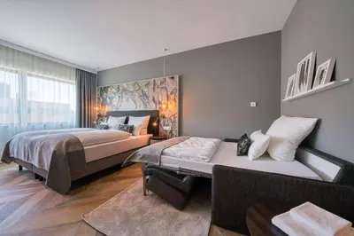 a bedroom with two beds and a large window at Vienna House Easy by Wyndham Amsterdam Airport Schiphol in Hoofddorp