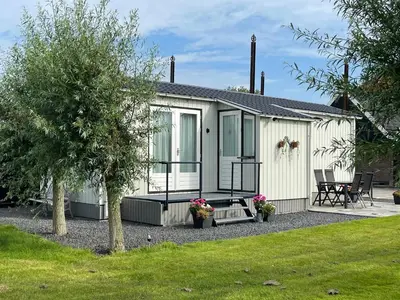 a mobile home with a patio and a yard at Welcome by Bianca in Jisp