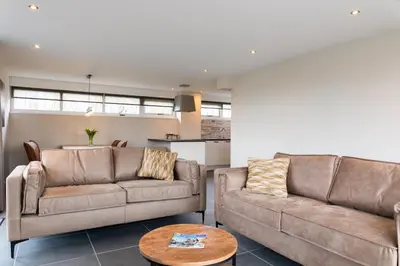 a living room with two couches and a table at Ruyge Weyde Logies - The Farmers Daughter in Oudewater