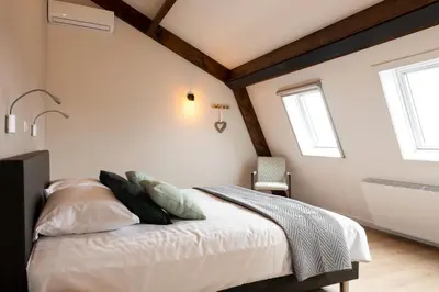a bedroom with a bed with white sheets and pillows at Ruyge Weyde Logies - The Farmers Daughter in Oudewater