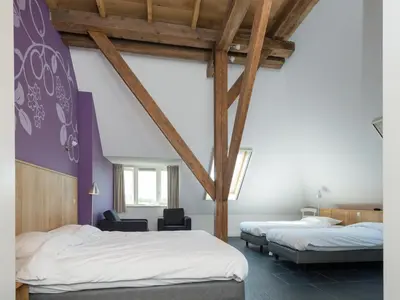 two beds in a room with wooden beams at Haven with Garden & Comfort in Zuidoostbeemster