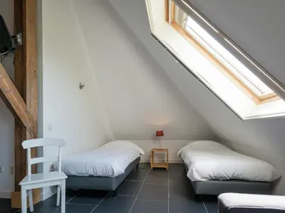 two beds in a room with two windows at Haven with Garden & Comfort in Zuidoostbeemster