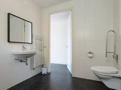 a bathroom with a sink and a toilet and a mirror at Haven with Garden & Comfort in Zuidoostbeemster